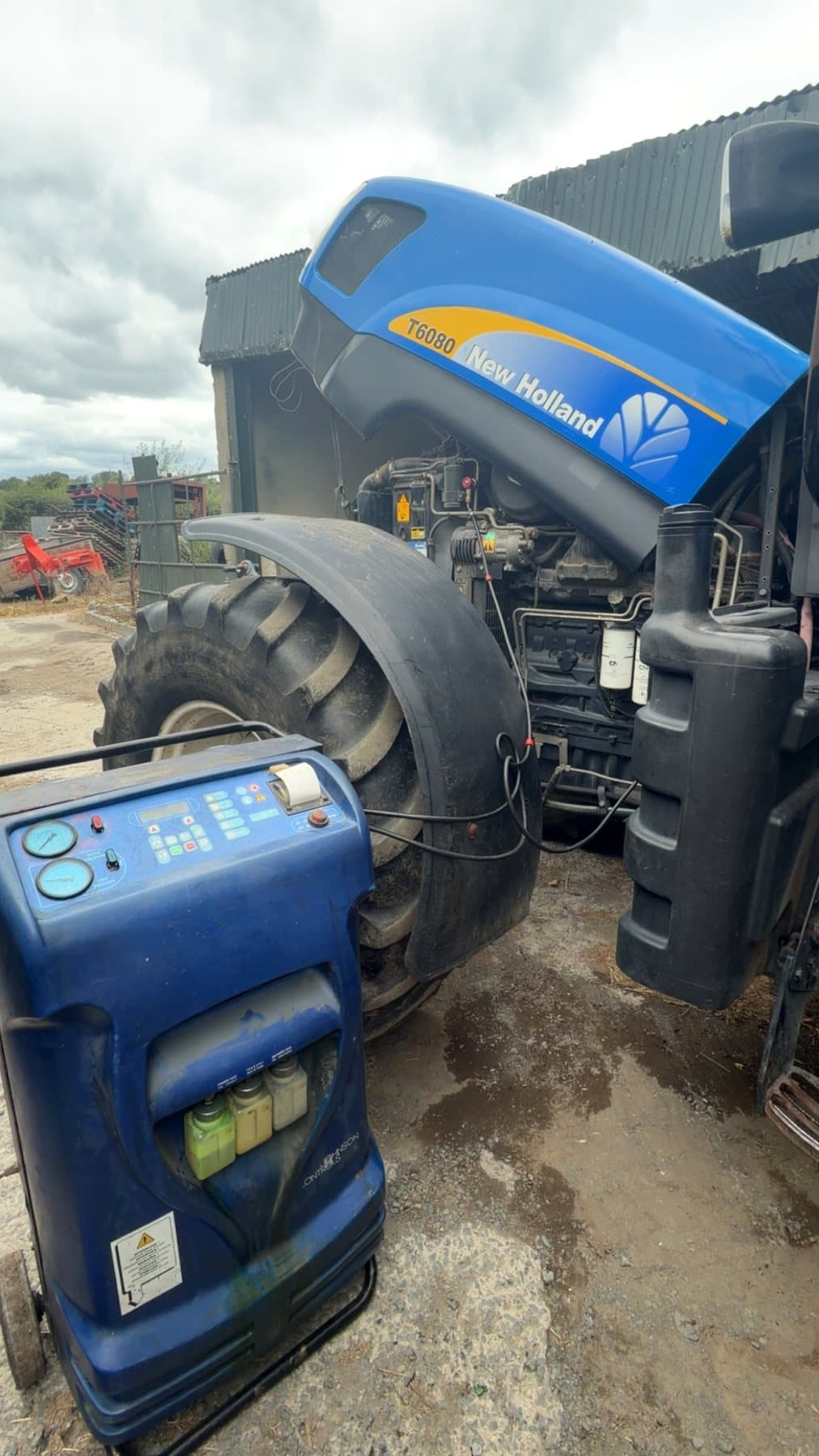 New Holland tractor connected to air conditioning service equipment